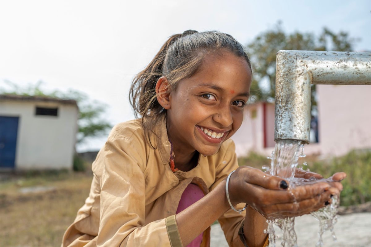 A girl at the newly installed hand pump at school in Rajasthan.