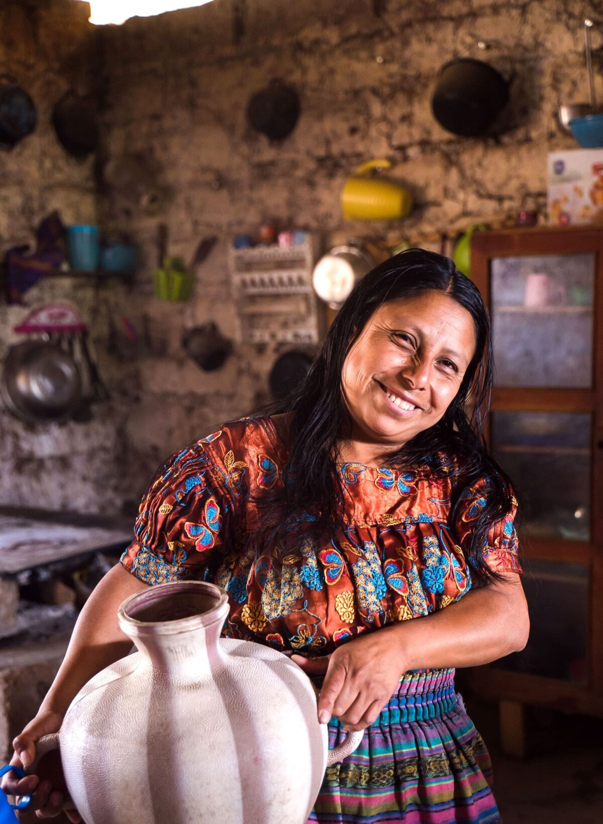 A woman with a vase of drinking water for consumption.
